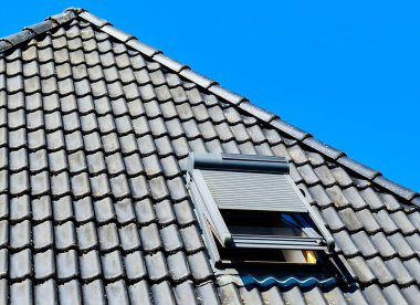 Siyah çatı kiremitleri ile Velux tarzı çatı penceresini aç