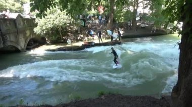 Münih, Almanya - 28 Temmuz 2024: Münih 'teki Isar nehrinin Eisbach dalgasında sörfçü