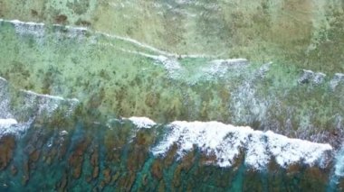 Maldivler kıyısındaki mercan resiflerinin üzerindeki güzel dalgaların drone görüntüsü..