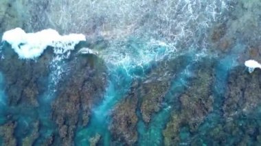 Maldivler kıyısındaki mercan resiflerinin üzerindeki güzel dalgaların drone görüntüsü..