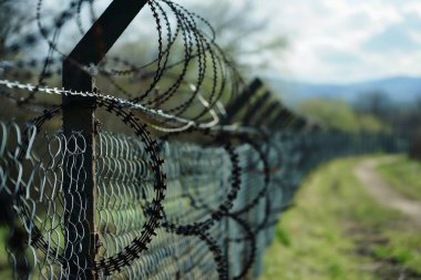 Dikenli telleri olan ve insan olmayan bir sınır çiti.