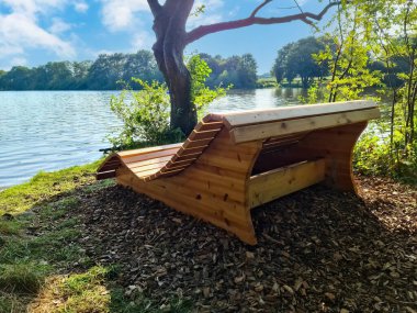 Göl kıyısında yeni ahşap bir bank Yoldan geçenlerin dinlenmesi için
