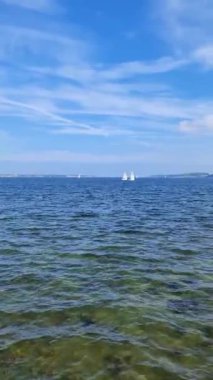 Ufukta birkaç yelkenli tekneyle Baltık Denizi 'nin mavi suları görünüyor..