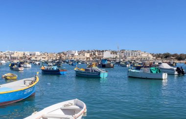 Marsaxlokk, Malta - 29. Eylül 2024: Malta 'daki Marsaxlokk limanında gün ışığında küçük balıkçı teknelerinin görüntüsü