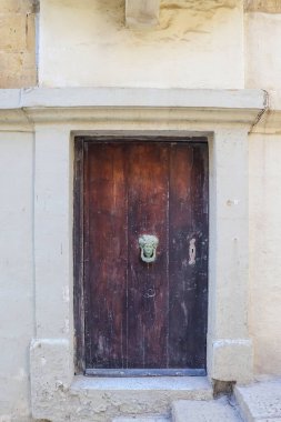 An old wooden blue door in a Mediterranean setting in a historic town in Italy clipart