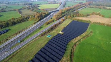 Alman otoyolu A7 'nin insansız hava aracı görüntüsü. Güneş parklarıyla dolu kırsal bir alanda yoğun trafik var..