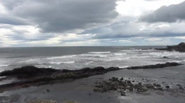 Büyük dalgalar İzlanda 'nın etkileyici kayalık kara sahillerine çarpar..