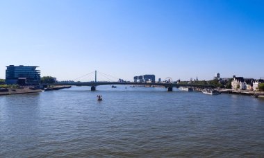 Almanya 'nın Köln kentindeki Ren nehrinin arka planında gökyüzünün ünlü binalarının olduğu güzel havaya bakın.