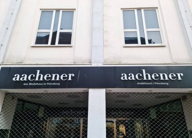 Flensburg, Almanya: 05. Aralık 2024: Bir mağazanın girişinin üstündeki Aachener Modehaus logosu