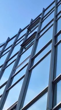 Modern ofis yüzleri cam ve yansıtan güneş ışığı ve bazı bulutlar ile.