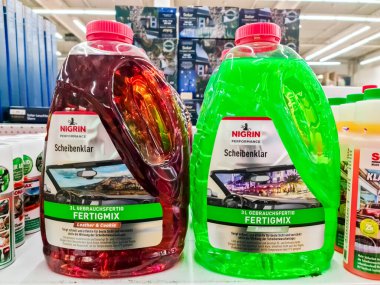 Kiel, Almanya 25 Ocak 2025: Bir mağaza rafında sergilenen kırmızı ve yeşil Nigrin Scheibenkler Fertigmix şişeleri, farklı mevsimler için özel cam temizleme çözümleri sunuyor
