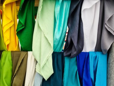 Bir mağazada asılı renkli kumaşların çeşitliliği, tekstil endüstrisi ve perakende konsepti