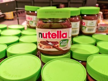 Hamburg, Almanya - 04. Şubat 2025: Süpermarket raflarında yeşil kapaklı pek çok Nutella kavanozu satın alınmaya hazır