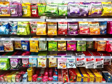 Hamburg, Almanya - 04. Şubat 2025: Bir süpermarkette raflarda sergilenen çeşitli ricola ve em-eukal öksürük pastili ve şekerlerden oluşan parlak renkli paketler