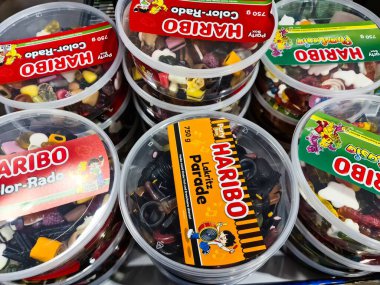 Hamburg,, Germany - 04. February 2025: Round plastic boxes of HARIBO brand candies, including Lakritz Parade, Color-Rado, and Phantasia, are stacked, creating a colorful display clipart