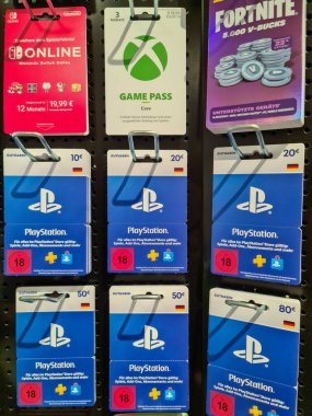 Hamburg, Almanya - 04. Şubat 2025: Playstation, Xbox Game Pass ve Nintendo Switch Online için ön ödemeli oyun kartları bir mağazadaki metal rafta sergilendi