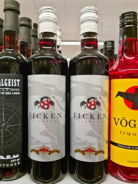 Hamburg, Almanya - 04. Şubat 2025: Birkaç şişe Ficken likörü ve diğer alkollü içecekler bir süpermarketteki rafta satılmaya hazır olarak sergileniyor