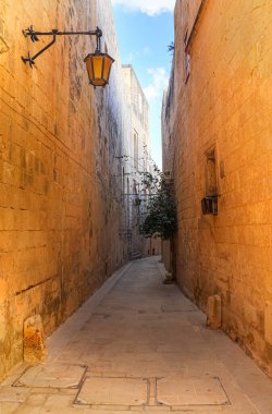 Mdina, Malta 30 Eylül 2024: Tarihi Mdina, Malta 'da taştan duvarları olan güneşli sokak
