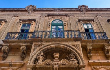 Mdina, Malta 30 Eylül 2024: Mdina 'da karmaşık ayrıntılar ve yeşil pencerelerle şık bir cephe