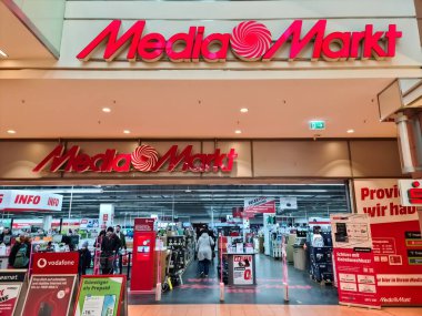 Kiel, 21 yaşında. Şubat 2025: Medya Markt tüketici perakende mağazasına giren müşteriler, çeşitli ürünler için araştırma ve alışveriş