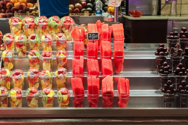 Барселона, 18. Июль 2024: Свежие фруктовые чашки, ломтики арбуза и вишни для продажи на рынке в Барселоне, Испания