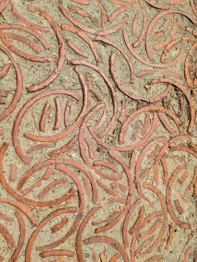 Karmaşık tuğla işçiliği eşmerkezli dairelerin büyüleyici bir modelini oluşturur ve bir yola sanatsal bir dokunuş ekler.