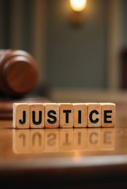 Tahta bloklar adaletin yerini bulması için arka planda tokmak olan yansıtıcı bir yüzeyde oturuyorlar.
