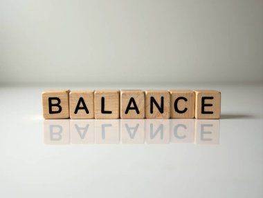 Tahta küplerin kelime dengesi yansıtıcı bir yüzey üzerinde durması istikrar ve denge kavramını temsil ediyor.
