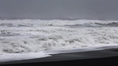 İzlanda 'daki Reynisfjara' ya vuran güçlü okyanus dalgaları yavaş hareket ediyor..