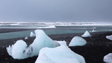 Buz kütleleri İzlanda 'daki siyah kumsalda dinleniyor.