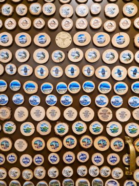 Reykjavik, İzlanda - 05. Mart 2025: İzlanda manzaraları, vahşi yaşam ve kültürel sembollerin yer aldığı renkli mıknatısların sergilenmesi için bir duvara yerleştirildi