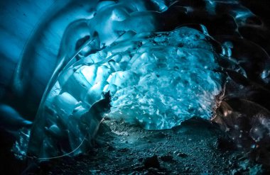 Işık, Vatnajokull Buzulu, İzlanda 'daki büyüleyici bir buz mağarası içindeki nefes kesici mavi buz oluşumlarından süzülerek büyülü bir sahne yaratıyor.