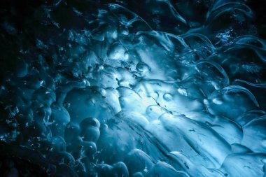 Vatnajokull, İzlanda 'daki bir buzul mağarasında aydınlatmalı mavi buz oluşumları büyüleyici bir doğa manzarası yaratıyor.