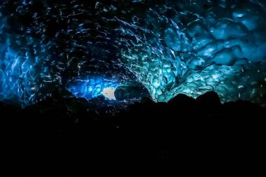 Işık, Vatnajokull Buzulu, İzlanda 'daki bir mağaradaki nefes kesen mavi buz oluşumlarından süzülerek büyülü, başka bir dünya manzarası yaratıyor.