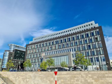 Berlin, Almanya 03. Ekim 2024, modern ofis binaları Berlin, Almanya 'da canlı mavi gökyüzü altında çağdaş kentsel mimari sergilenmektedir.