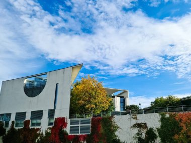 Berlin, Almanya 03. Ekim 2024, Berlin 'deki Alman Başbakanlık binasının modern mimarisi, canlı bir sonbahar yeşilliği ve açık mavi bir gökyüzü içeriyor.