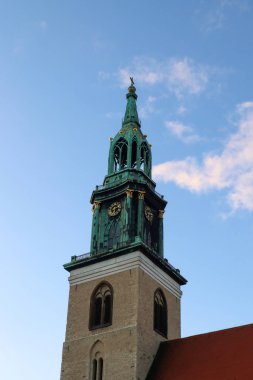 Berlin, Almanya 03. Ekim 2024, St. Mary Kilisesi 'nin yeşil bakır kulesi Berlin' in tarihi bir simgesi olan mavi gökyüzüne doğru yükseliyor.