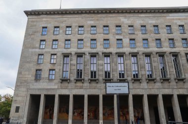 Berlin, Almanya 03. Ekim 2024, Haus des Lehrers 'ın geniş pencereli ve sütunlu ön cephesinin alçak açılı görüntüsü, Platz des Volksaufstandes von 1953 işareti gösteriyor
