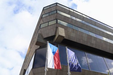 Berlin, Almanya 03. Ekim 2024 'te, Çek Cumhuriyeti' nin AB üyeliğini temsil eden Çek ve Avrupa bayrakları Berlin 'deki çağdaş bir binanın önünde rüzgarda sallanıyordu.