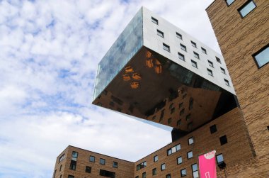 Berlin, Almanya 03. Ekim 2024, Berlin, Almanya 'da yansıtıcı dış görünüş ve bulutlu gökyüzü ile modern mimari yapıya alçak açı