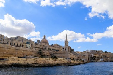 Valletta, Malta 27. Eylül 2024, Malta 'nın başkenti Valletta' nın tahkimatı ve ufuk çizgisinin panoramik manzarası, beyaz bulutlu mavi bir gökyüzü altında