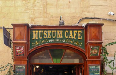 Valletta, Malta 27. Eylül 2024, 1921 'de Valletta, Malta' da kurulan Müze Cafe 'nin Wooden vintage tabelasında kahve, pizza ve pastizzi reklamları yer alıyor.