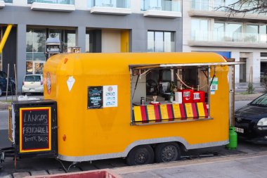 Valletta, Malta 27. Eylül 2024, Malta Valletta 'da bir caddeye park edilmiş küçük sarı yemek kamyonu lango, frikandel ve bitterballen gibi Macar sokak yemekleri satıyor.
