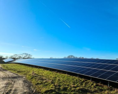 Mükemmel mavi gökyüzü altında sürdürülebilir bir şekilde yenilenebilir enerji sağlayan büyük fotovoltaik bitki