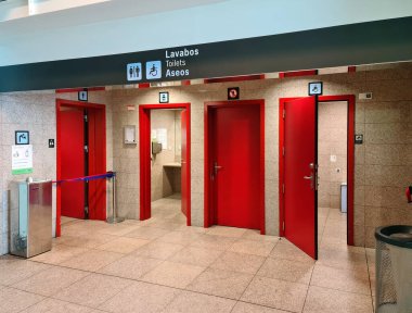 Barselona, İspanya 21. Temmuz 2024, Barselona Havalimanı 'ndaki umumi tuvaletlerin kırmızı kapıları. Tuvaletler, tuvaletler ve aseolar yazıyor. Engelliler için erişilebilirliği gösteriyor.