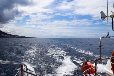 Güneşli bir günde Tenerife kıyısından yelken açıp, okyanusun, bulutların ve dalgalı mavi gökyüzünün tadını çıkarıyorum.