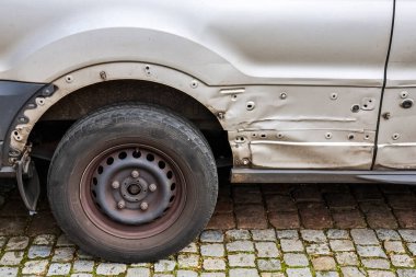 Kiel, Almanya 'da 15 Mart 2025' te kaldırım taşı sokağına park edilmiş hasarlı beyaz bir minibüse yaklaş.