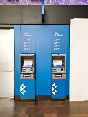 Keflavik, İzlanda 23. Haziran 2024, Keflavik Havalimanı 'nda iki mavi Hradbanki ATM' si EUR, USD, GBP, NOK ve DKK para birimlerini gösteriyor