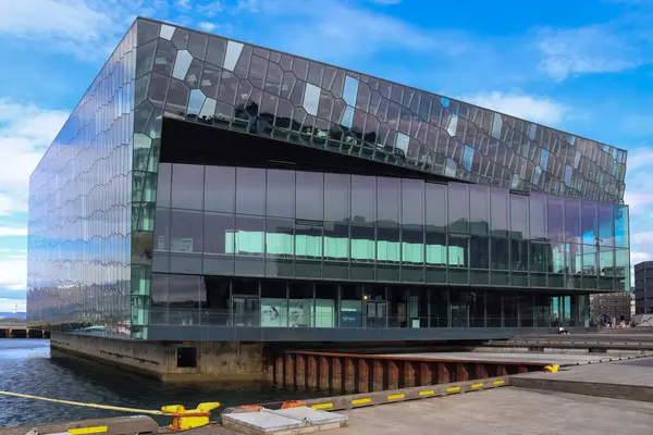 Harpa Konser Salonu, güneşli bir günde parlak mavi gökyüzünü yansıtıyor. Reykjavik 'in modern mimarisi ve şehir cazibesini gözler önüne seriyor.