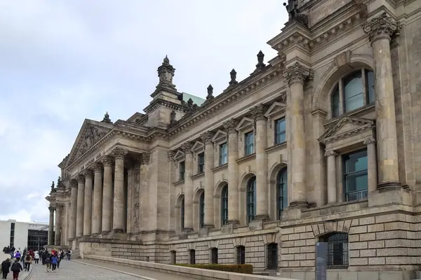Reichstag binası yakınında yürüyen turistler, Almanya 'nın en popüler turizm merkezi olan Berlin' de Alman Parlamentosu 'nun merkezi.